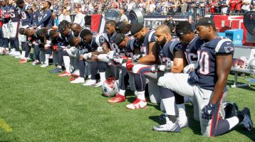 Jugadores de la NFL y dueños de equipos desafían a Trump arrodillándose durante el himno